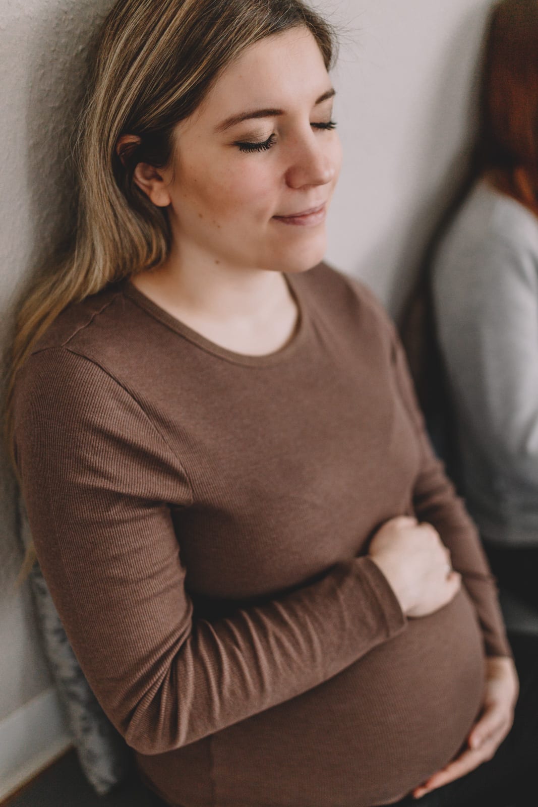 Businessfotos Schwangere umfasst Babybauch bei Meditation